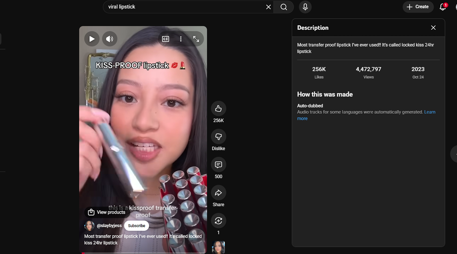 Screenshot of a beauty creator holding lipstick with on-screen text “KISS-PROOF lipstick.”